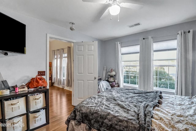 bedroom with hardwood / wood-style flooring, vaulted ceiling, and ceiling fan