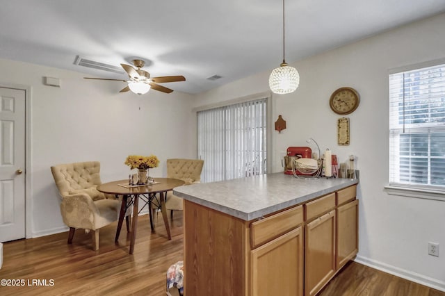 kitchen with decorative light fixtures, wood-type flooring, kitchen peninsula, and ceiling fan