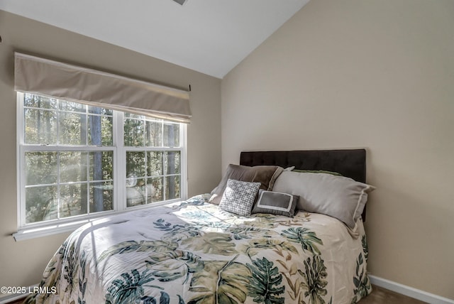 bedroom featuring multiple windows and lofted ceiling