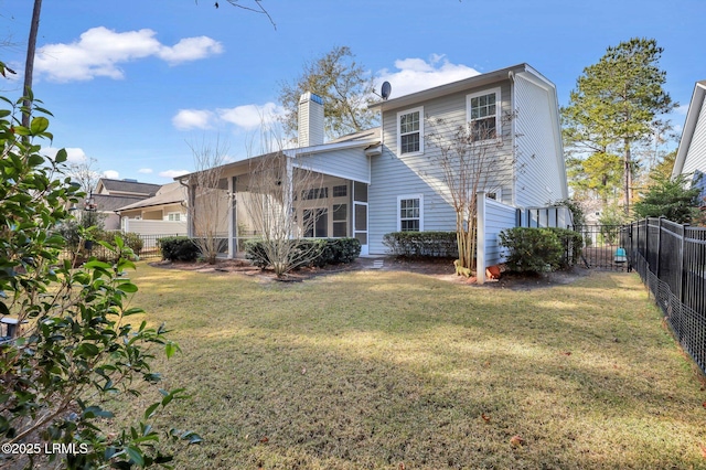 rear view of house with a sunroom and a lawn