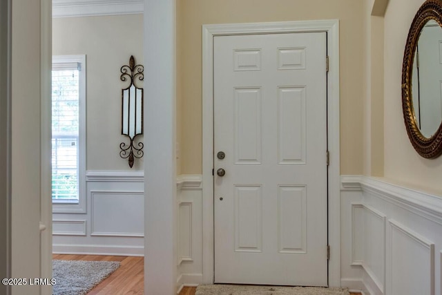 entrance foyer featuring ornamental molding and light hardwood / wood-style floors