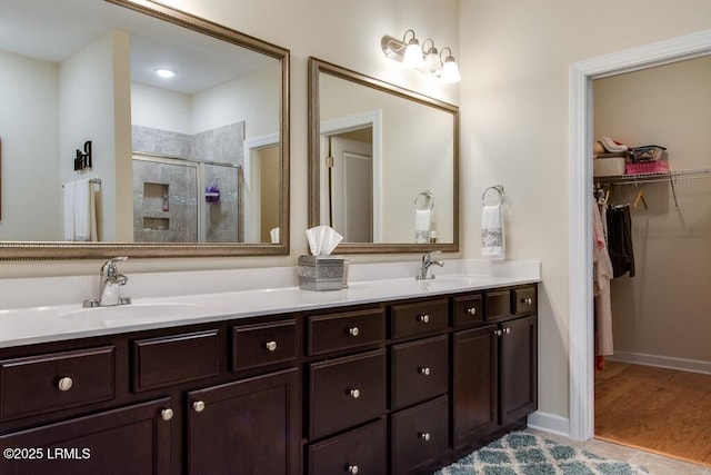 bathroom with vanity, a shower with shower door, and hardwood / wood-style floors