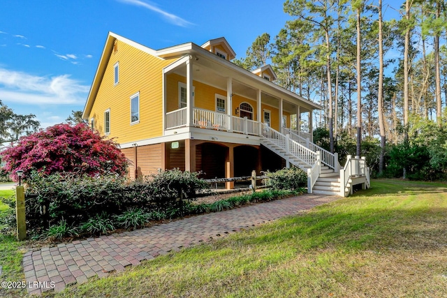 view of front of home with stairs, a porch, and a front lawn