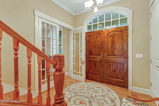 entryway featuring an inviting chandelier, stairway, wood finished floors, and baseboards