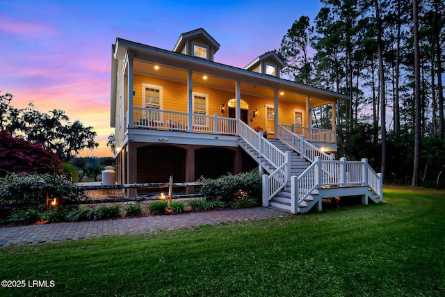 view of front of property with stairs, a porch, a yard, and an attached garage