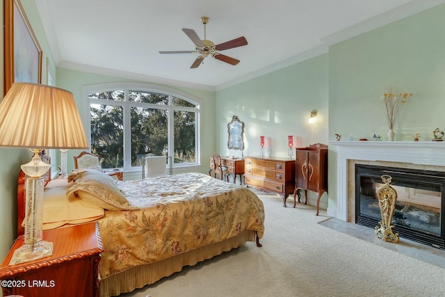 bedroom featuring a tile fireplace, a ceiling fan, carpet, and ornamental molding