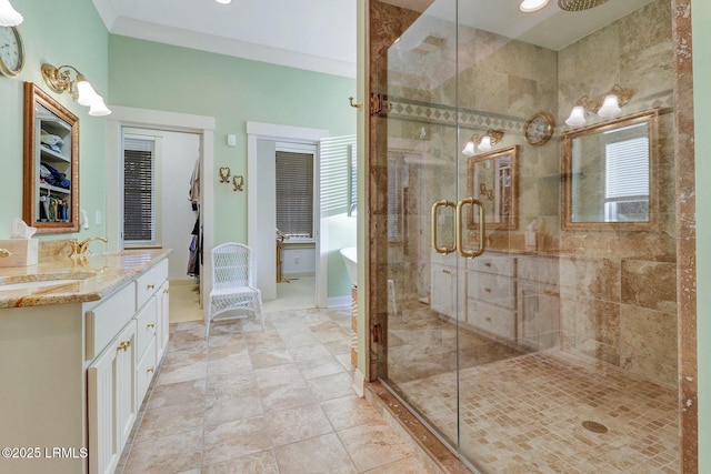 full bathroom with a sink, a shower stall, crown molding, double vanity, and a soaking tub