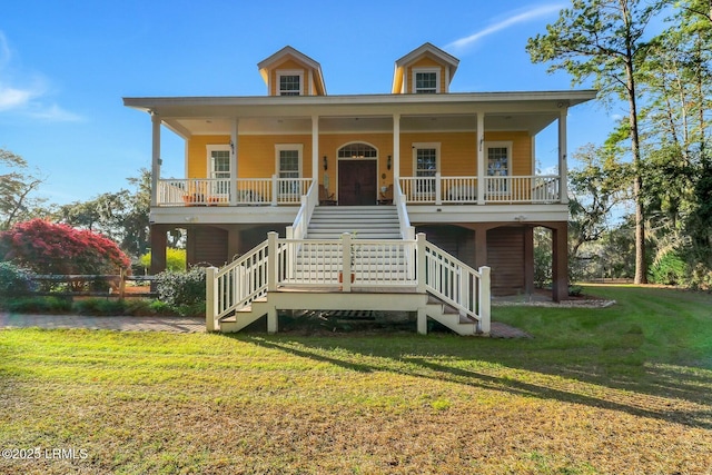 coastal inspired home with a front yard, covered porch, and stairs