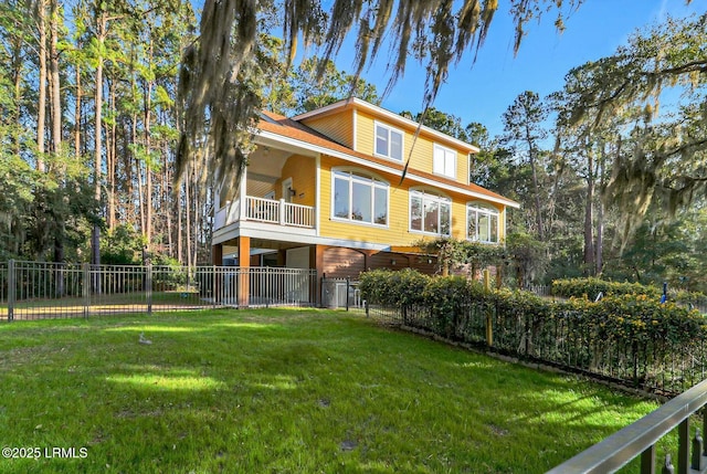 rear view of house featuring a lawn, a balcony, and fence