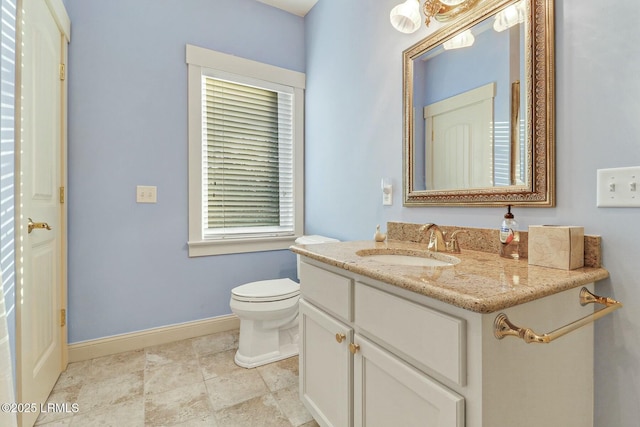 bathroom featuring vanity, toilet, and baseboards