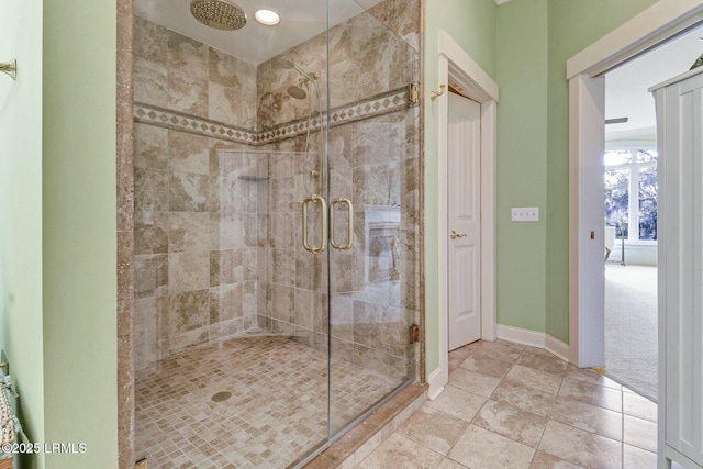 full bath with a stall shower and baseboards