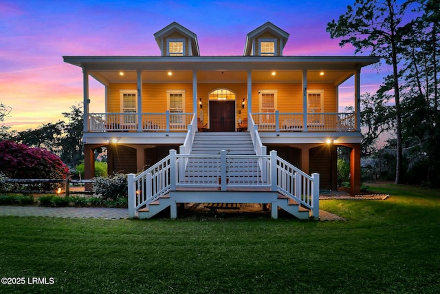 beach home featuring a porch, stairs, and a front lawn