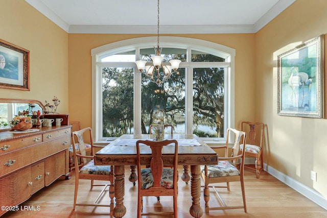 dining space with baseboards, plenty of natural light, light wood-style floors, and an inviting chandelier