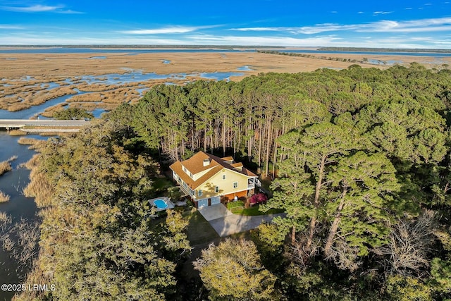 aerial view with a wooded view and a water view