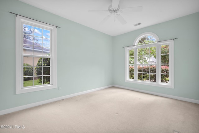 unfurnished room featuring carpet, a healthy amount of sunlight, and ceiling fan