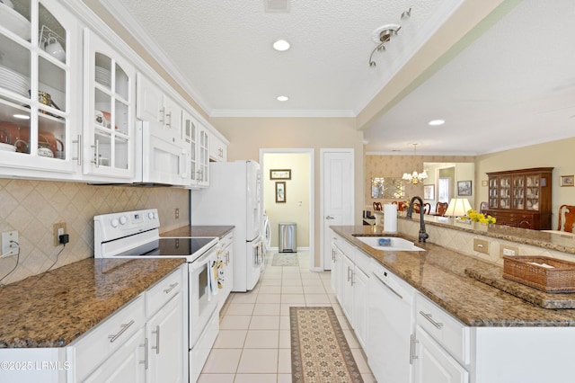 kitchen featuring a sink, a textured ceiling, white appliances, light tile patterned flooring, and crown molding