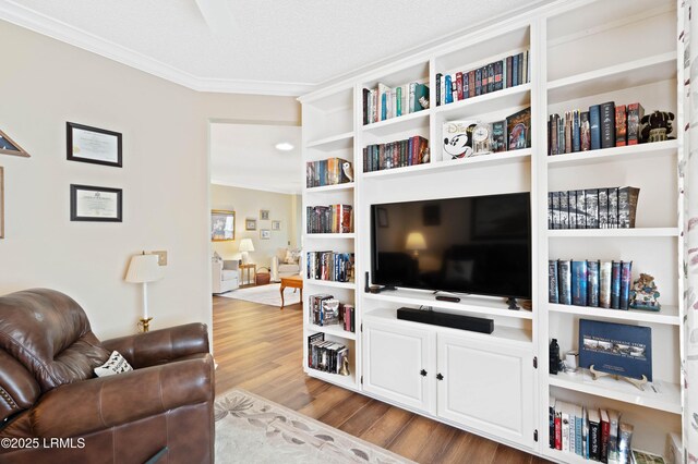 living area featuring wood finished floors and ornamental molding