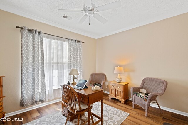 office space with visible vents, a healthy amount of sunlight, wood finished floors, and a ceiling fan