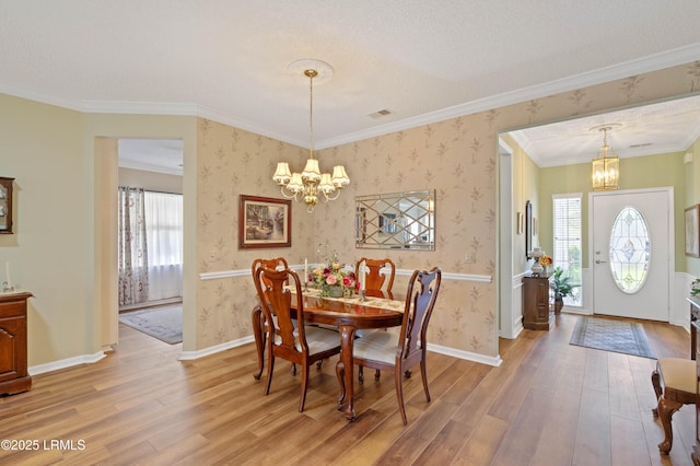 dining area featuring visible vents, light wood finished floors, a chandelier, and wallpapered walls
