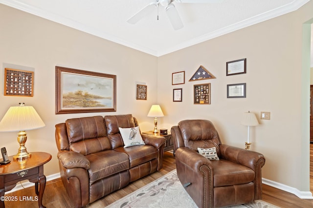 living room featuring ornamental molding, wood finished floors, baseboards, and ceiling fan