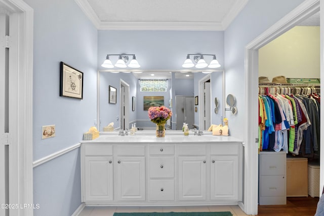 full bathroom with double vanity, crown molding, and a sink