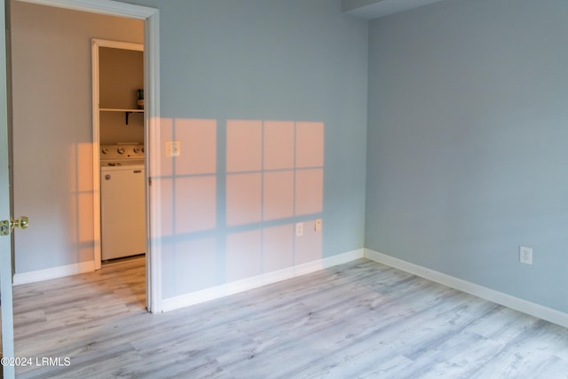 empty room featuring washer / clothes dryer and light hardwood / wood-style flooring