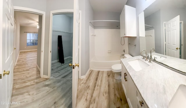 full bathroom featuring vanity, wood-type flooring, shower / washtub combination, and toilet