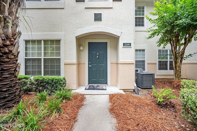 897 Fording Island Rd Unit 209, Bluffton, SC 29910 - view of exterior entry with stucco siding and cooling unit