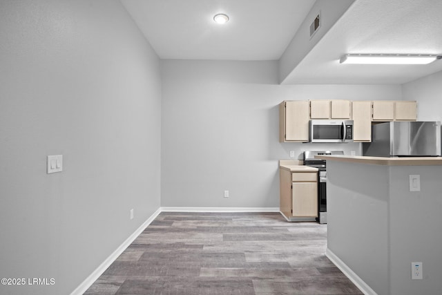 897 Fording Island Rd Unit 209, Bluffton, SC 29910 - kitchen featuring stainless steel appliances, light brown cabinets, light wood-style flooring, baseboards, and light countertops