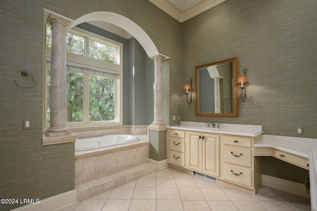 bathroom with tile patterned flooring, decorative columns, vanity, ornamental molding, and tiled bath