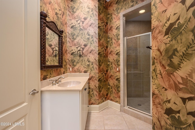 bathroom with tile patterned flooring, vanity, and walk in shower