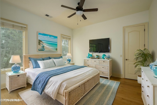 bedroom featuring light wood-style flooring, ceiling fan, and visible vents