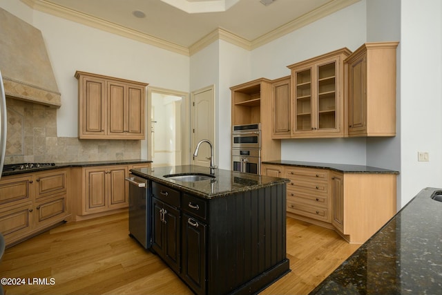 kitchen featuring premium range hood, sink, dark stone countertops, ornamental molding, and stainless steel appliances