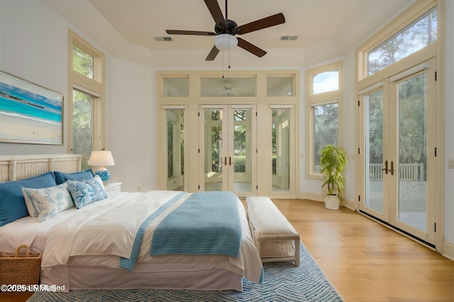 bedroom featuring light wood-style floors, french doors, access to outside, and visible vents