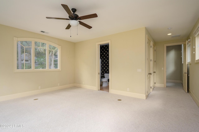 spare room with light carpet, baseboards, a ceiling fan, and visible vents