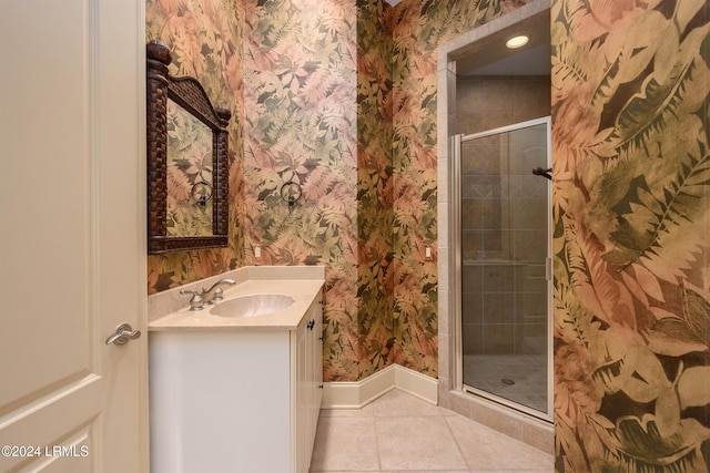 bathroom with vanity, tile patterned flooring, a stall shower, wallpapered walls, and baseboards