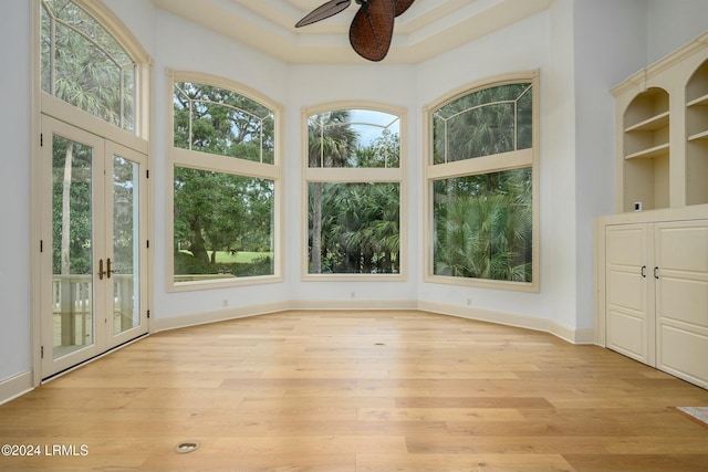 unfurnished sunroom featuring ceiling fan