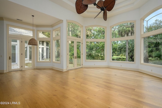 unfurnished sunroom featuring a tray ceiling and ceiling fan