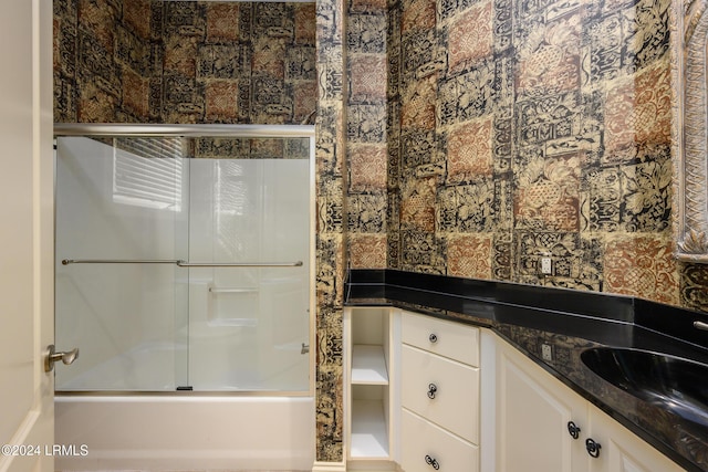 bathroom featuring vanity and shower / bath combination with glass door