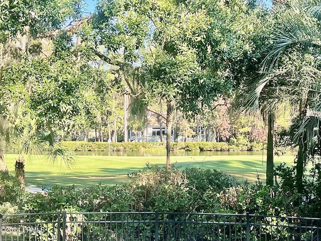 view of community featuring a yard and fence