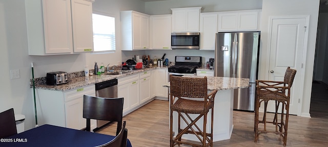 12 Pacolet Ln, Beaufort, SC 29906 - kitchen with stainless steel appliances, light wood-style flooring, a sink, and white cabinetry