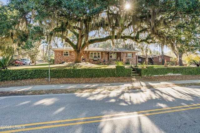 single story home featuring brick siding