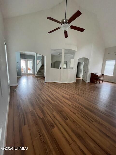 unfurnished living room featuring dark wood-type flooring, high vaulted ceiling, french doors, and ceiling fan