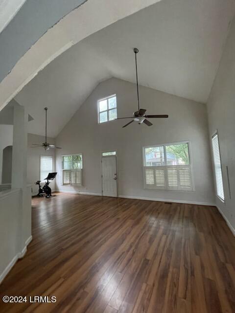 unfurnished living room featuring ceiling fan, dark hardwood / wood-style flooring, and high vaulted ceiling