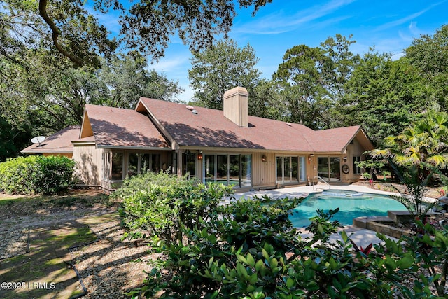 13 Annabella Ln, Hilton Head Island, SC 29926 - rear view of property featuring a chimney, a patio area, and an outdoor pool
