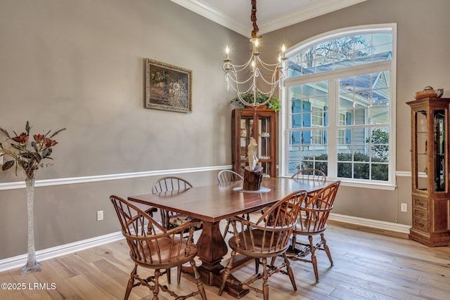 dining space featuring a notable chandelier, crown molding, and light hardwood / wood-style floors