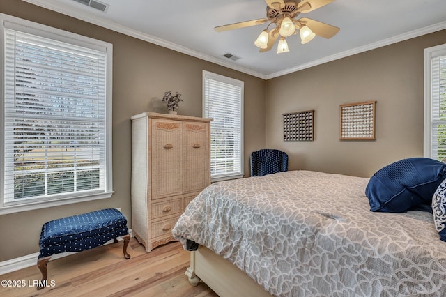 bedroom with crown molding, hardwood / wood-style floors, and multiple windows