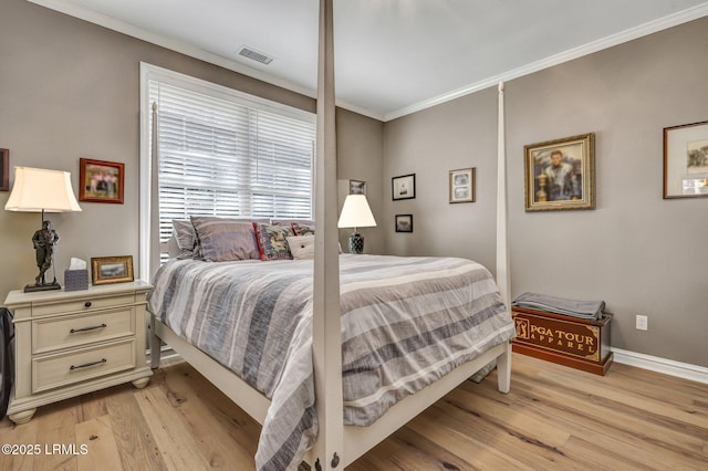 bedroom featuring crown molding and light wood-type flooring