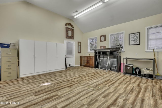 interior space with light hardwood / wood-style flooring and high vaulted ceiling