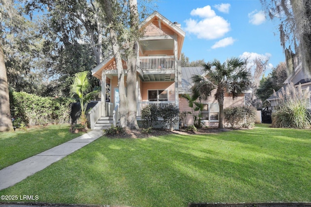 view of front facade with a balcony and a front lawn